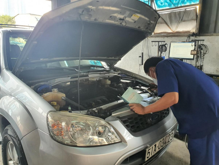 Kiểm định viên đang kiểm tra động cơ xe. Ảnh: THY NHUNG