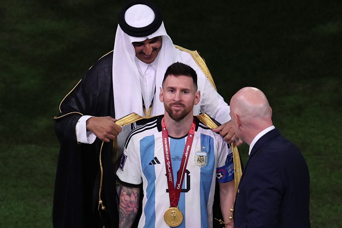 Tiểu vương Qatar Sheik Tamim bin Hamad Al Thani khoác chiếc áo "Bisht" cho Messi trước giờ nâng cúp vô địch. Ảnh: Getty