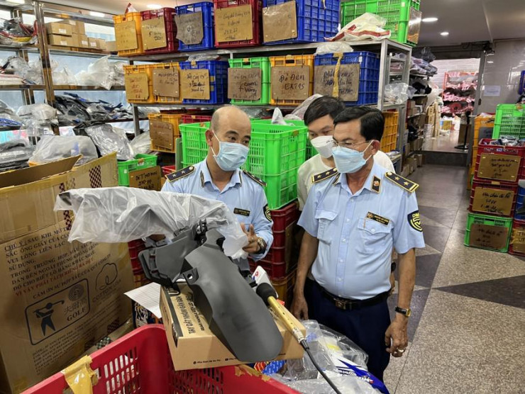 Lực lượng Quản lý thị trường đang làm việc tại một cửa hàng kinh doanh phụ tùng xe máy trong Chợ Tân Thành. Ảnh: Tổng cục QLTT.