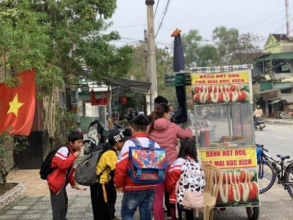 Học sinh mua đồ ăn vặt tại các hàng quán trước cổng trường