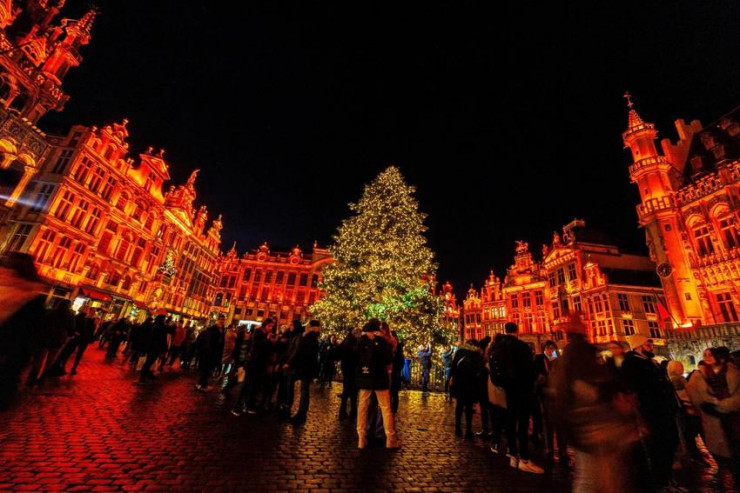 Du khách đứng trước cây thông Noel tại tòa thị chính ở thủ đô Brussels (Bỉ). Ảnh: AP