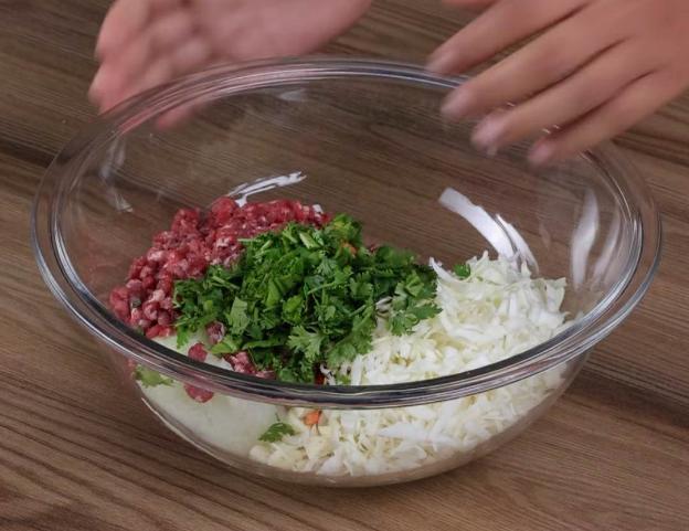 Cho cả chút ớt bột loại không cay để tạo màu và cuối cùng trút rau mùi đã xắt nhỏ vào trong bát.