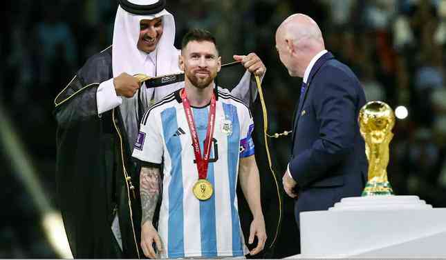 Tiểu vương Qatar choàng chiếc áo choàng đen viền vàng cho Lionel Messi (Ảnh: AFP).