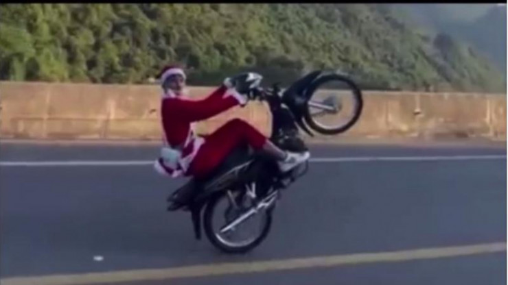 Tùng mặc quần áo “ông già Noel” điều khiển xe máy bốc đầu trên cao tốc.