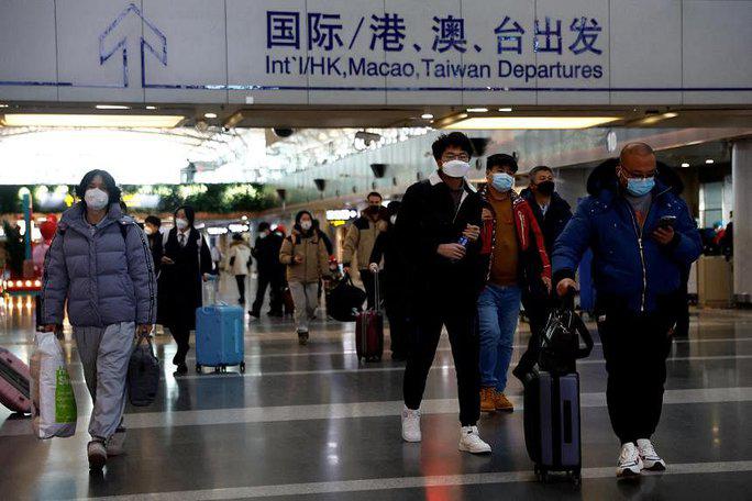 Hành khách tại sân bay quốc tế Bắc Kinh ngày 27-12. Ảnh: Reuters