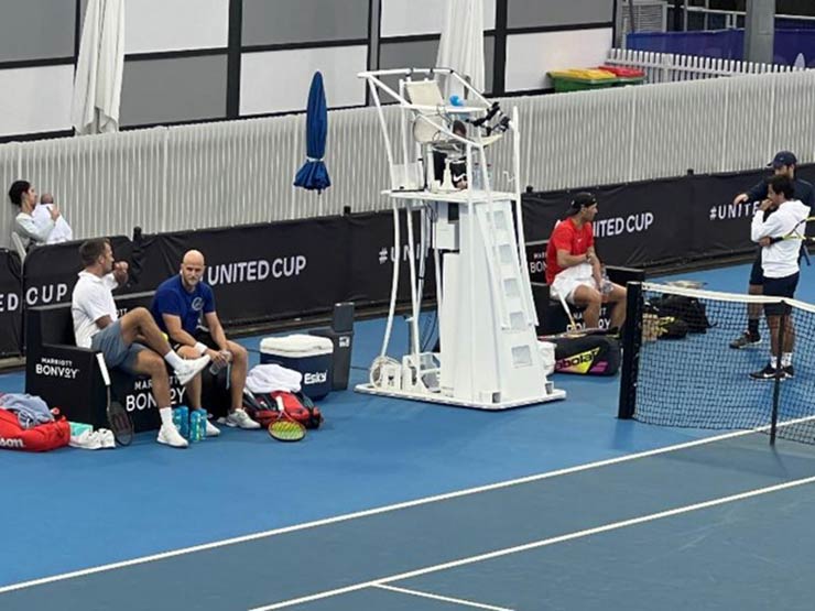 Vợ con Nadal ngồi ở góc trái ảnh, tránh bóng bay ra ngoài sân, trong khi Nadal mặc áo đỏ