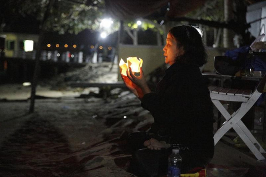 Một người thắp hoa đăng cầu nguyện cho các nạn nhân vụ lật ca nô (Ảnh: PLO)