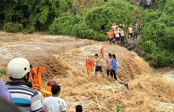Lực lượng cứu hộ tiếp cận các em hỏ giữa dòng nước lũ