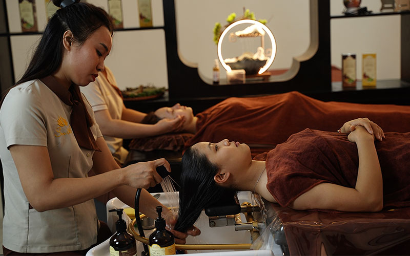 Nhân viên Spa Sen 365 sử dụng Dầu gội thảo dược Sen 365 để gội đầu cho khách hàng