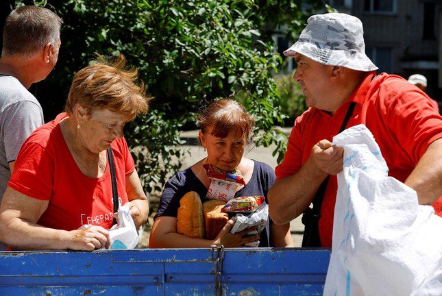 Người dân Ukraine nhận hàng tiếp tế sau vụ vỡ đập Nova Kakhovka ngày 17/6. (Ảnh: Reuters)