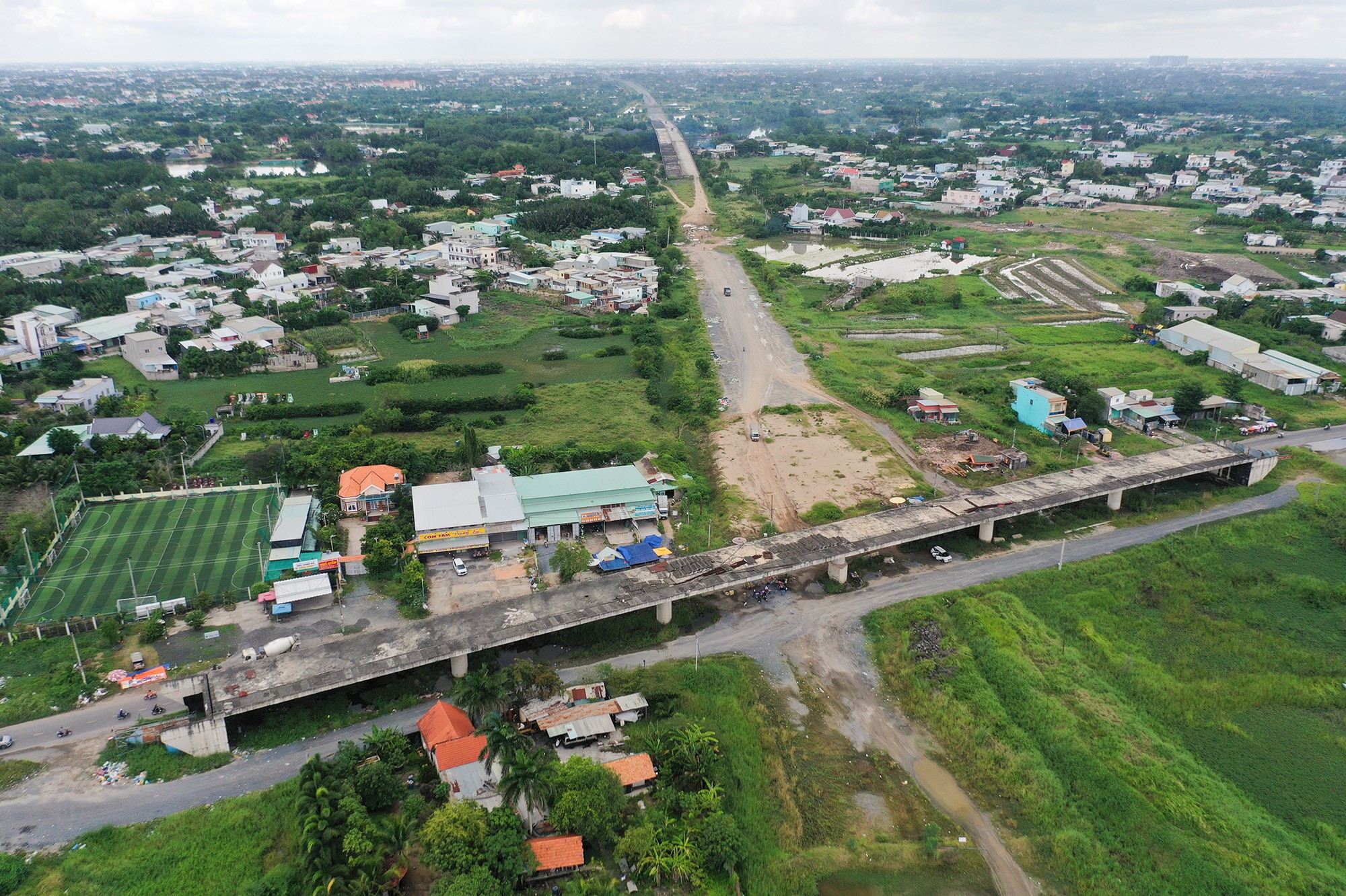 Hạng mục cầu vượt quốc lộ 50 băng qua cao tốc nằm trơ trọi khi mới thi công được kết cấu chính, nhiều vật liệu xây dựng, máy móc tập trung từ trên mặt cầu đến phần đường dẫn. Đường cao tốc hướng đi Bến Lức, Long An đoạn giáp nút giao vẫn là đường đất, rải đá dăm…