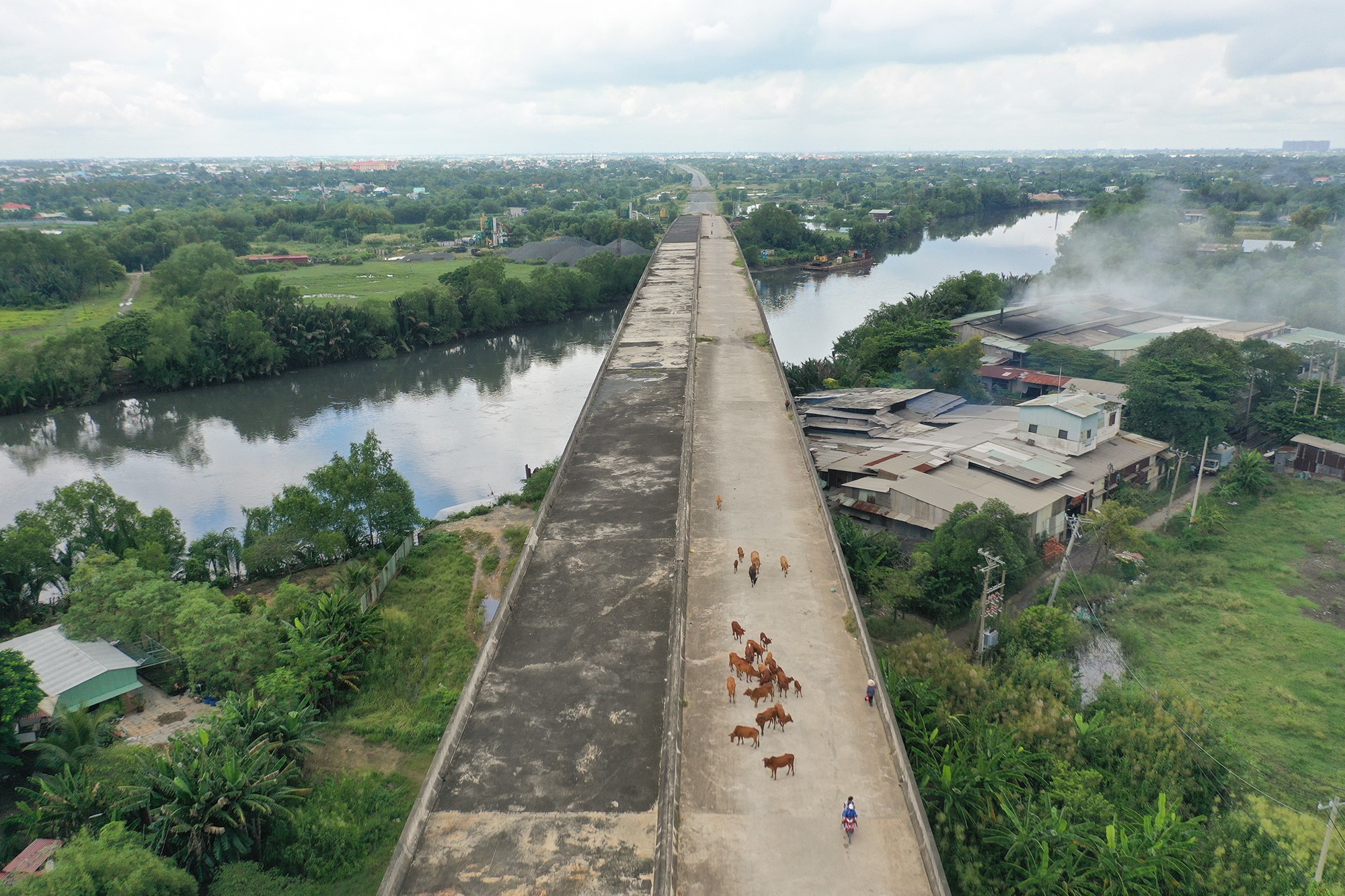 Cây cầu thuộc cao tốc bắc qua kênh cách nút giao khoảng 500m chỉ mới hoàn thành kết cấu chính, bê tông xám xịt sau thời gian dài ngừng thi công.