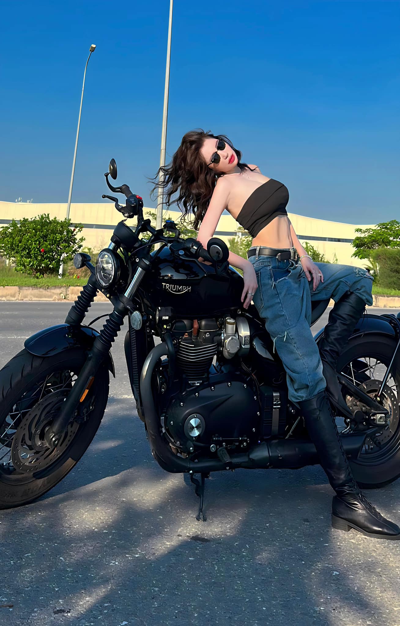 Elly Trần cá tính, quyến rũ với mốt áo quây, quần jeans, tạo dáng bên xe moto.