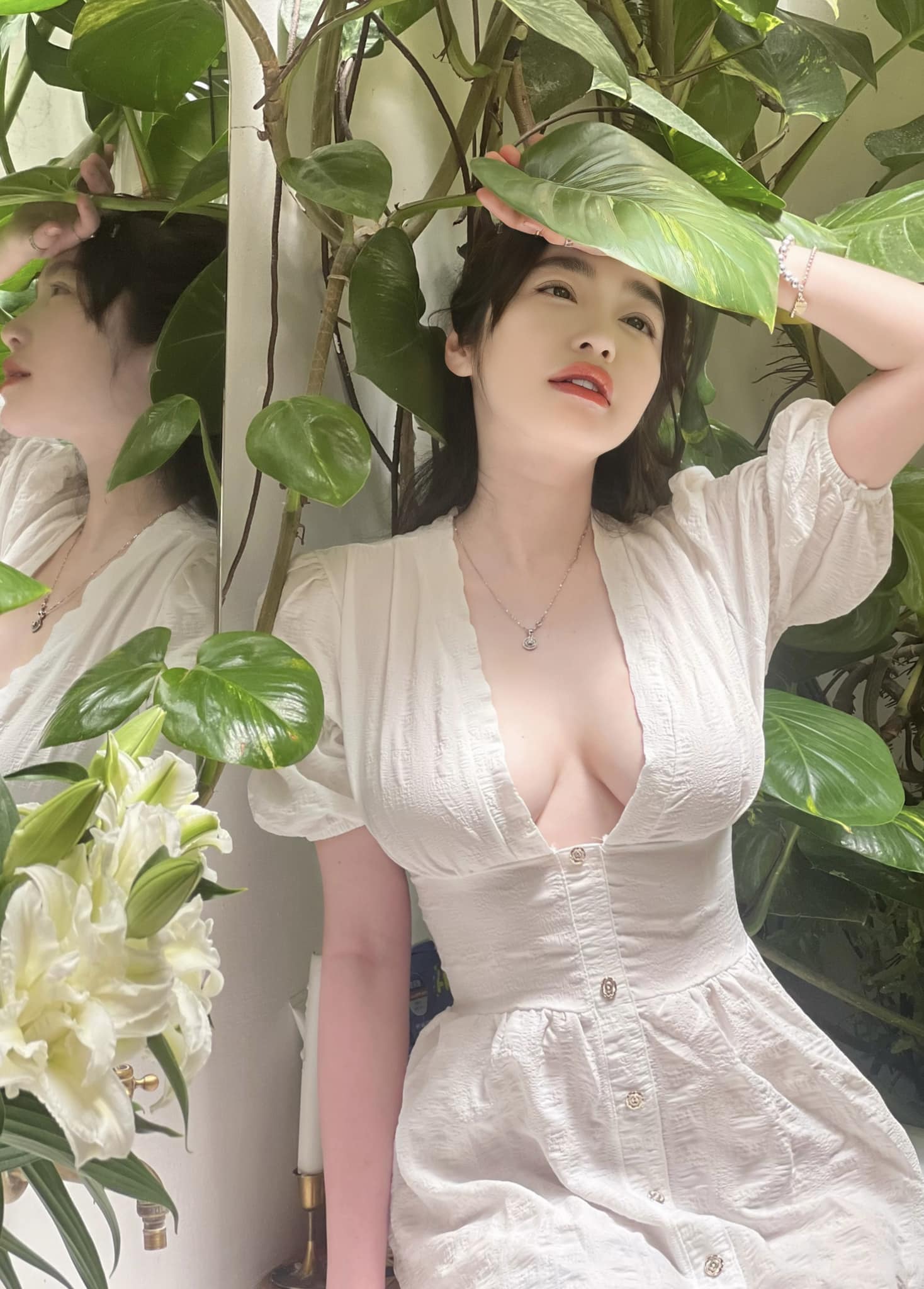 Trong concept chụp hình với cây hoa, Elly Trần được nhận xét "đẹp như thiếu nữ". Cô diện váy dài màu trắng, điểm nhấn là phần cổ xẻ sâu&nbsp;làm tăng thêm vẻ quyến rũ cho người mặc.&nbsp;