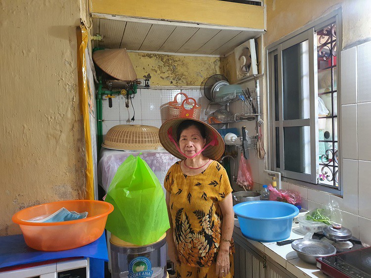 Gian bếp nhỏ của gia đình bà Minh Anh với gần chục chiếc chậu hứng nước dột từ mái xuống, nấu cơm bà cũng phải đội nón.