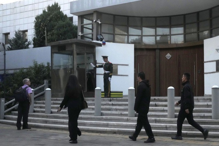 Cảnh sát Trung Quốc và người đi đường trước đại sứ quán Israel tại Trung Quốc hôm 13-10. Ảnh: AP