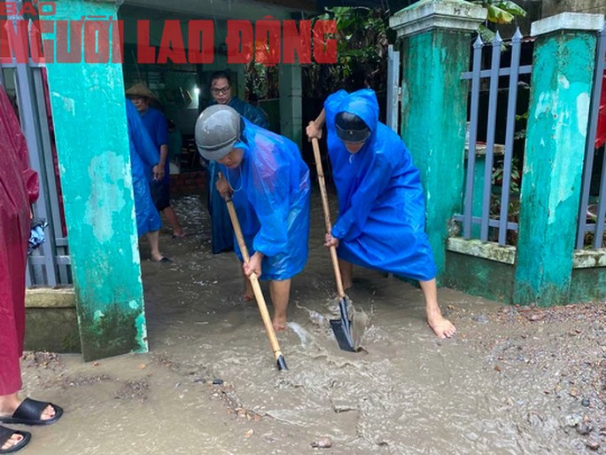Lực lượng tình nguyện của phường Hòa Thọ Tây sáng 14-10 phải tập trung xuống xúc bùn, đất ra ngoài giúp dân