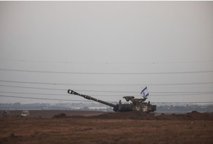 Khẩu pháo tự hành treo cờ Israel gần Dải Gaza hôm 22-10. Ảnh: Reuters