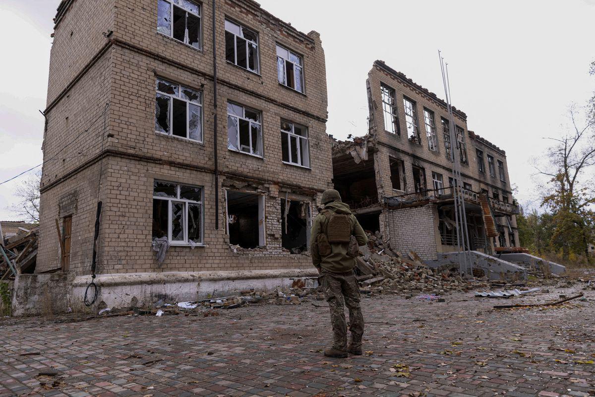Quân nhân Ukraine đứng gần một&nbsp;tòa nhà đổ nát ở Avdiivka.