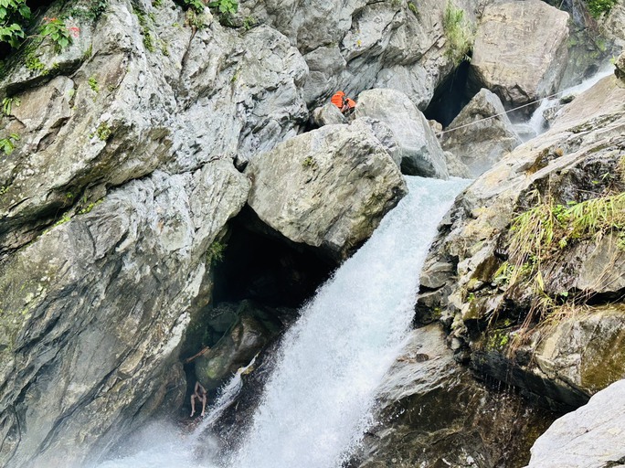 Du khách ngoại quốc bị mắc kẹt trong hốc đá, bên ngoài là con thác đang chảy xiết