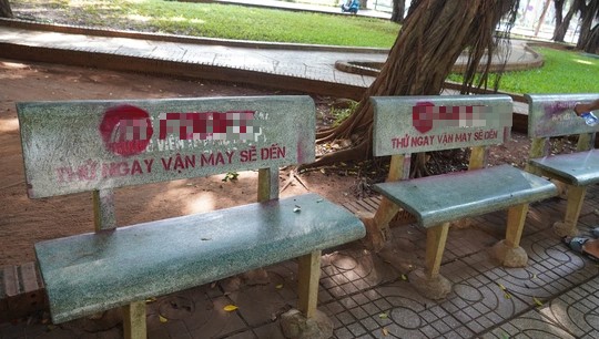 Hàng ghế đá bị sơn logo kèm dòng chữ quảng cáo trang cá cược trực tuyến