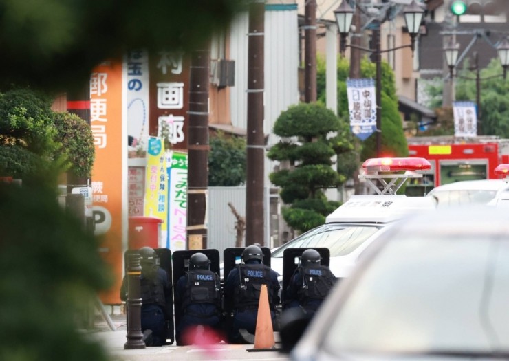 Cảnh sát bên ngoài bưu điện nơi nghi phạm ẩn náu. Ảnh: JapanTimes
