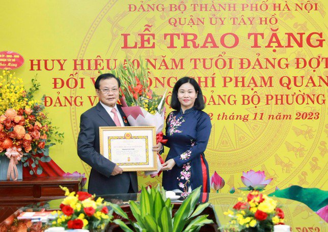 Phó Bí thư Thường trực Thành ủy Hà Nội Nguyễn Thị Tuyến trao tặng huy hiệu 50 năm tuổi Đảng tới ông Phạm Quang Nghị