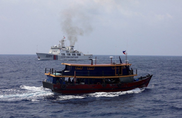 Tàu Cảnh sát biển Trung Quốc đi cạnh một tàu tiếp tế của Philippines đang làm nhiệm vụ tiếp tế gần bãi Cỏ Mây (thuộc quần đảo Trường Sa của Việt Nam) ngày 4-10. Ảnh: REUTERS