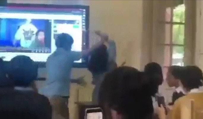 Hình ảnh nam giáo viên cầm tay đẩy nữ đồng nghiệp ra khỏi phòng học.