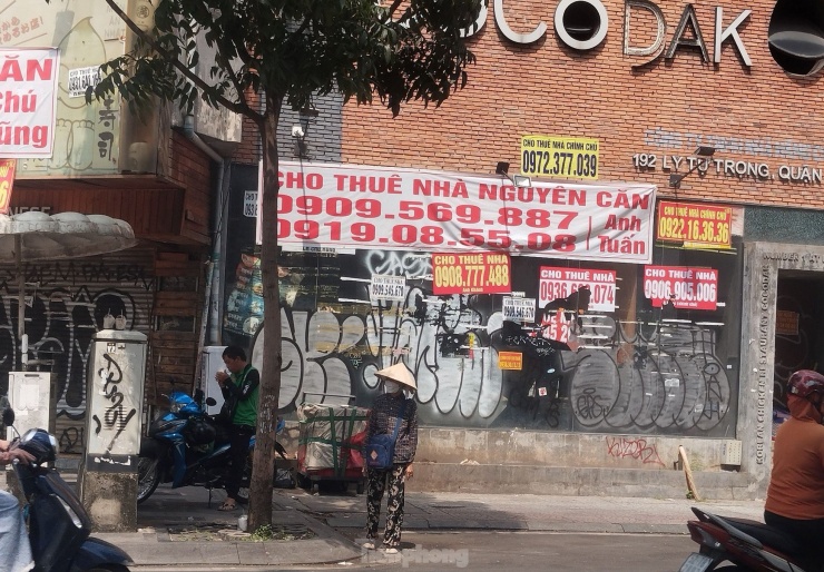 Anh N (35 tuổi, tài xế xe công nghệ) cho biết, cách đây vài năm, lô góc giao giữa đường Lý Tự Trọng và Trương Định được coi là vị trí gần như cố định của anh để đón khách vì lượng người ra vào các cửa hàng, quán ăn ở đây rất đông (ảnh trái). Năm nay, các mặt bằng đóng cửa và treo biển sang nhượng, cho thuê lại nên anh phải di chuyển vị trí đón khách đi xe. (Ảnh: Lộc Liên)
