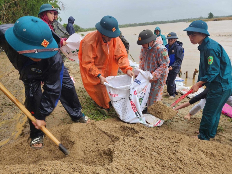 Sáng 14/11, nhiều người dân cùng lực lượng chức năng địa phương đội mưa, tập trung gia cố vùng ven sông Vu Gia bị sạt lở nghiêm trọng.