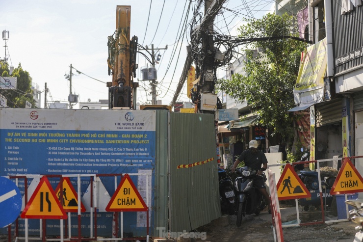 Người dân đi đường Nguyễn Duy Trinh (TP Thủ Đức) gặp nhiều vất vả do lô cốt của dự án vệ sinh môi trường TP.HCM (giai đoạn 2) chiếm hơn nửa mặt đường trong hơn một tháng qua.