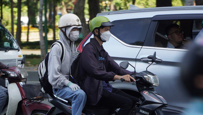 Người dân TP HCM mặc thêm áo để giữ ấm khi đi trên đường