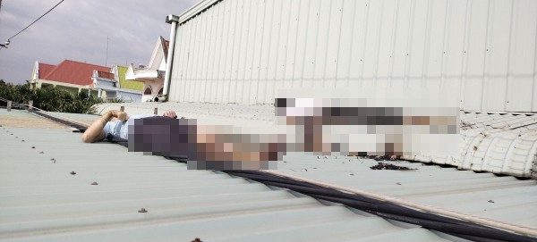 Hai nạn nhân bị điện giật nằm bất động trên mái nhà.
