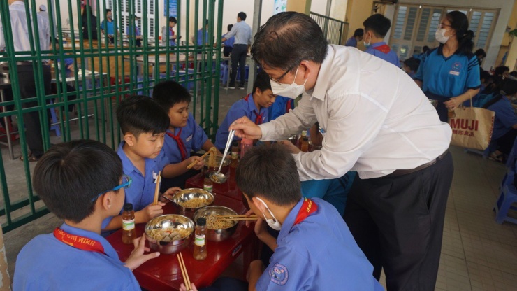 Thầy Đinh Phú Cường, Hiệu trưởng Trường THCS Nguyễn Văn Luông, quận 6, đang tiếp thực phẩm cho học sinh trong bữa ăn bán trú. Theo thầy Cường, để có trường học hạnh phúc thì hiệu trưởng phải luôn mở lòng lắng nghe giáo viên và học sinh. Ảnh: NGUYỄN QUYÊN