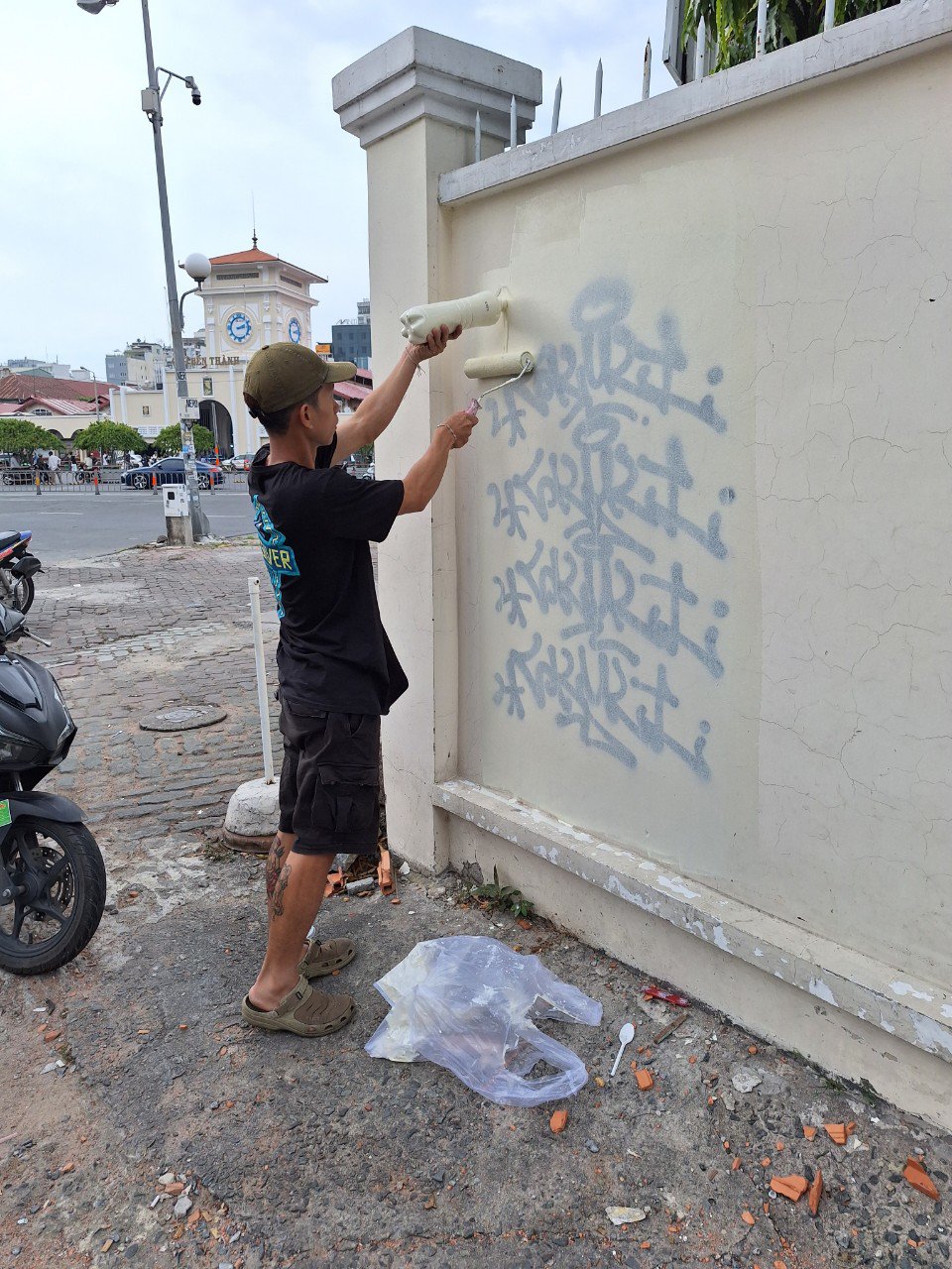 Thanh niên tẩy xóa nét vẽ bậy, sơn lại bức tường