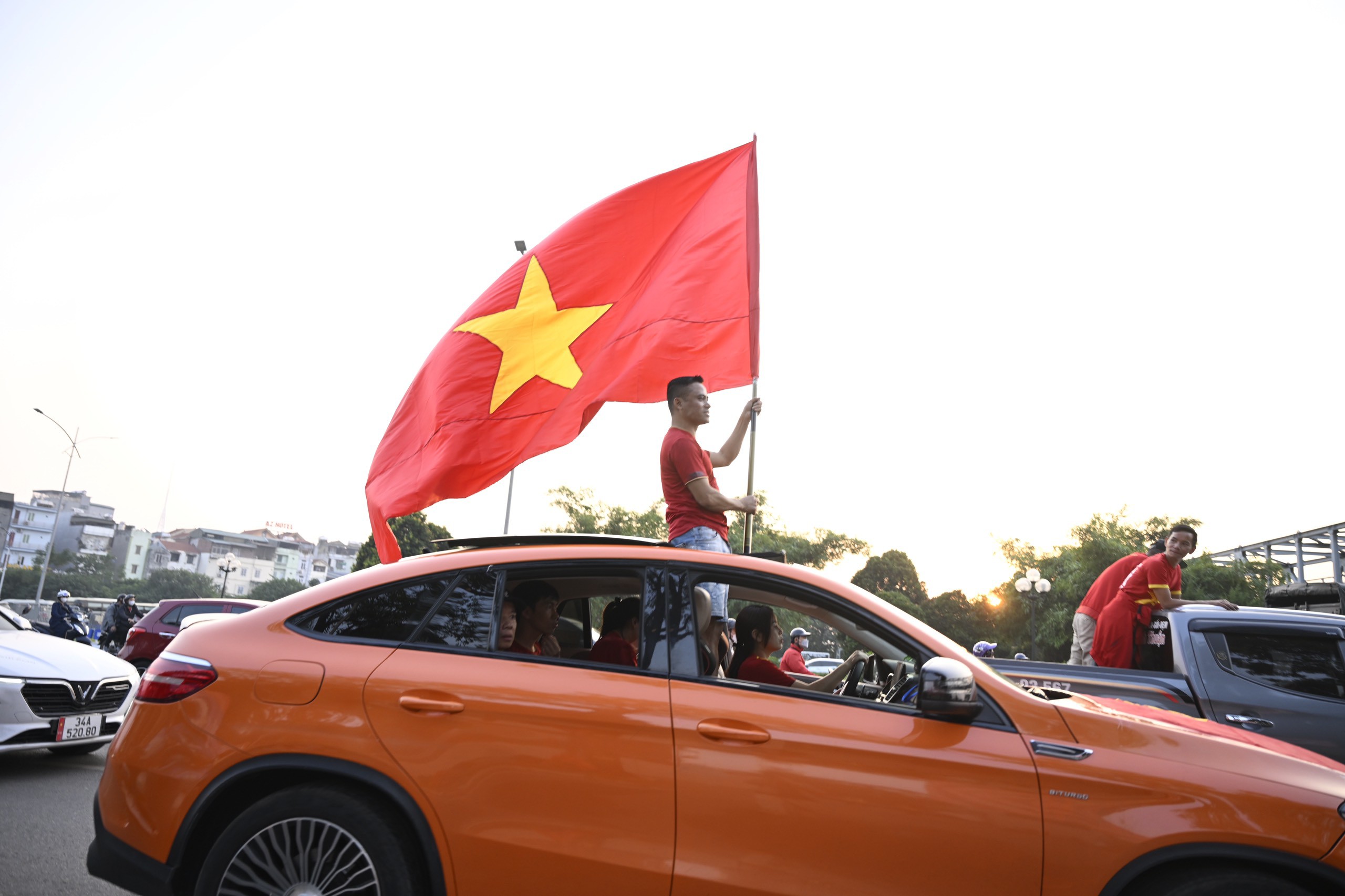 Dòng người “nối đuôi” nhau diễu hành, khoác lên sắc đỏ rực rỡ hoà cùng tiếng kèn, tiếng loa phát thanh và hô to “Việt Nam vô địch - Việt Nam vô địch” vang vọng tuyến phố.