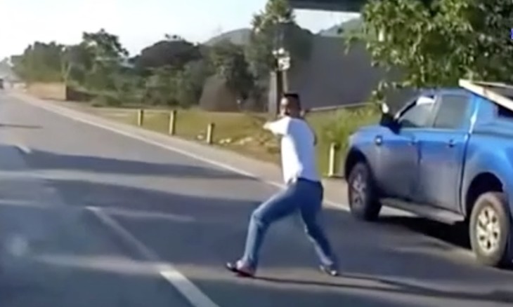 Người đàn ông cầm gậy golf lao ra giữa đường dọa vụt vào chiếc ôtô con đang đi đến.