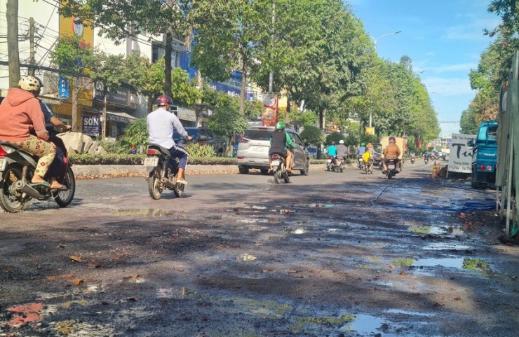 Mặt đường nước chảy trơn trượt gây khó khăn cho người tham gia giao thông.