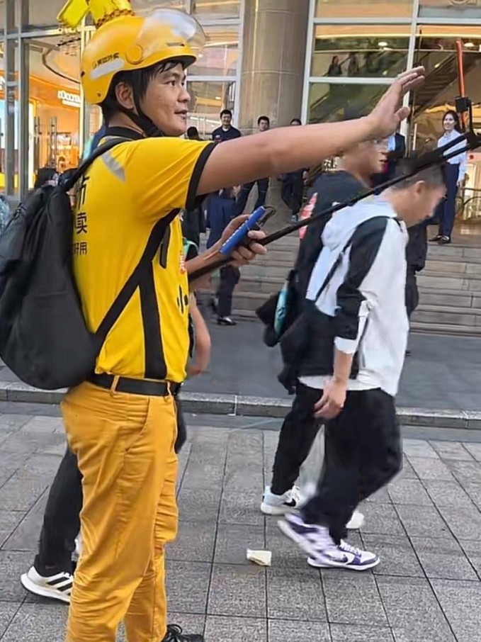 Trên con phố đi bộ Đông Môn nổi tiếng ở Thâm Quyến, một người đàn ông mặc đồng phục giao hàng Meituan (nền tảng đặt đồ ăn online hàng đầu Trung Quốc) bước đi và hát trong nỗ lực thu hút sự chú ý của người qua đường.