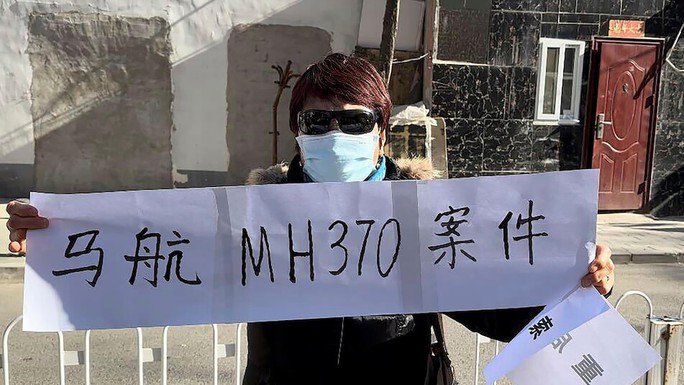 Hu Xiufang có con trai, con dâu và cháu gái trên chuyến bay MH370 giăng biểu ngữ "Vụ kiện MH370 của Malaysia Airlines" ở Bắc Kinh. Ảnh: AP