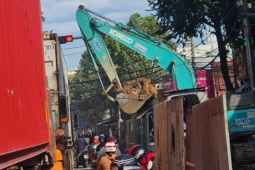 Tin tức trong ngày - Gầu máy xúc đầy đất công trình chống ngập lơ lửng trên đầu người đi đường