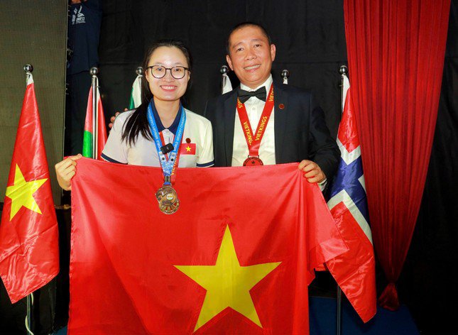 Đặng Ngọc Phương Trinh (bên trái) và tấm huy chương vàng tại cuộc thi Siêu trí nhớ thế giới 2023