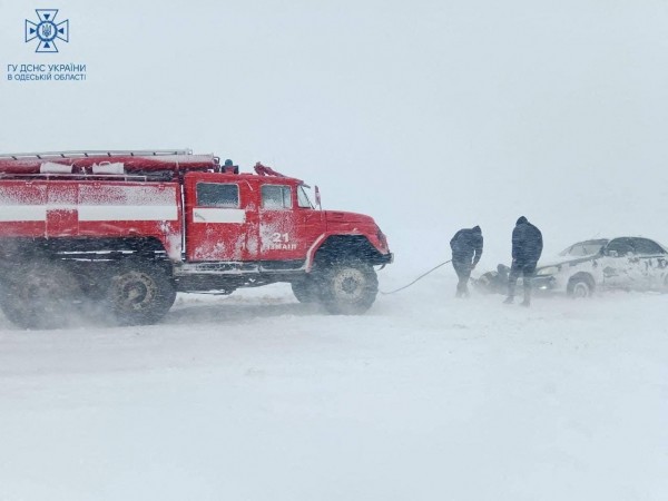 Lực lượng cứu hộ cố gắng giải cứu một chiếc xe mắc kẹt trong tuyết trên cao tốc. Ảnh: Reuters