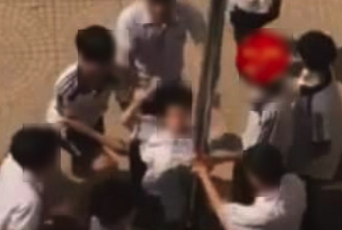 Nhóm học sinh Trường THCS Hoà Nam nhấc bạn học lớp 8 rồi thúc vùng kín vào cột. Ảnh cắt từ clip