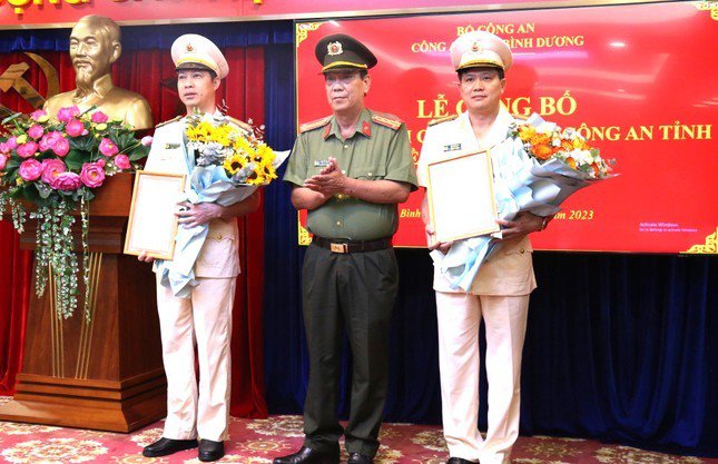 Đại tá Nguyễn Văn Dựt, Phó Giám đốc Công an tỉnh Bình Dương trao quyết định cho thượng tá Lưu Minh Hoàng (bìa trái) và thượng tá Đặng Đình Hà (bìa phải)