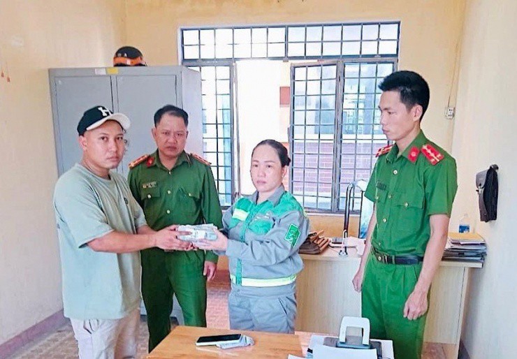 Nữ lao công nhặt được gần 100 triệu liền mang đến công an nhờ tìm người đánh rơi. Ảnh: HP