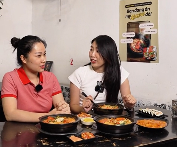 Food vlogger A dinosaur in the kitchen (bên phải) chia sẻ cảm nghĩ về mì cay tại quán Mr.Pan (Hà Nội)