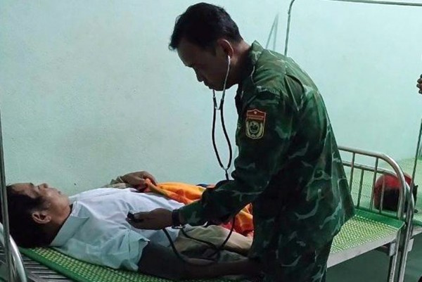 Cán bộ Quân y Đồn Biên phòng Ga Ry, huyện Tây Giang thăm khám sức khỏe cho bệnh nhân bị ngộ độc do nấm rừng. Ảnh: CTV