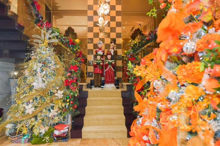 Không gian cầu thang gắn đèn chùm và
trang trí dãy hoa 2 bên cùng nhiều cây thông Noel.